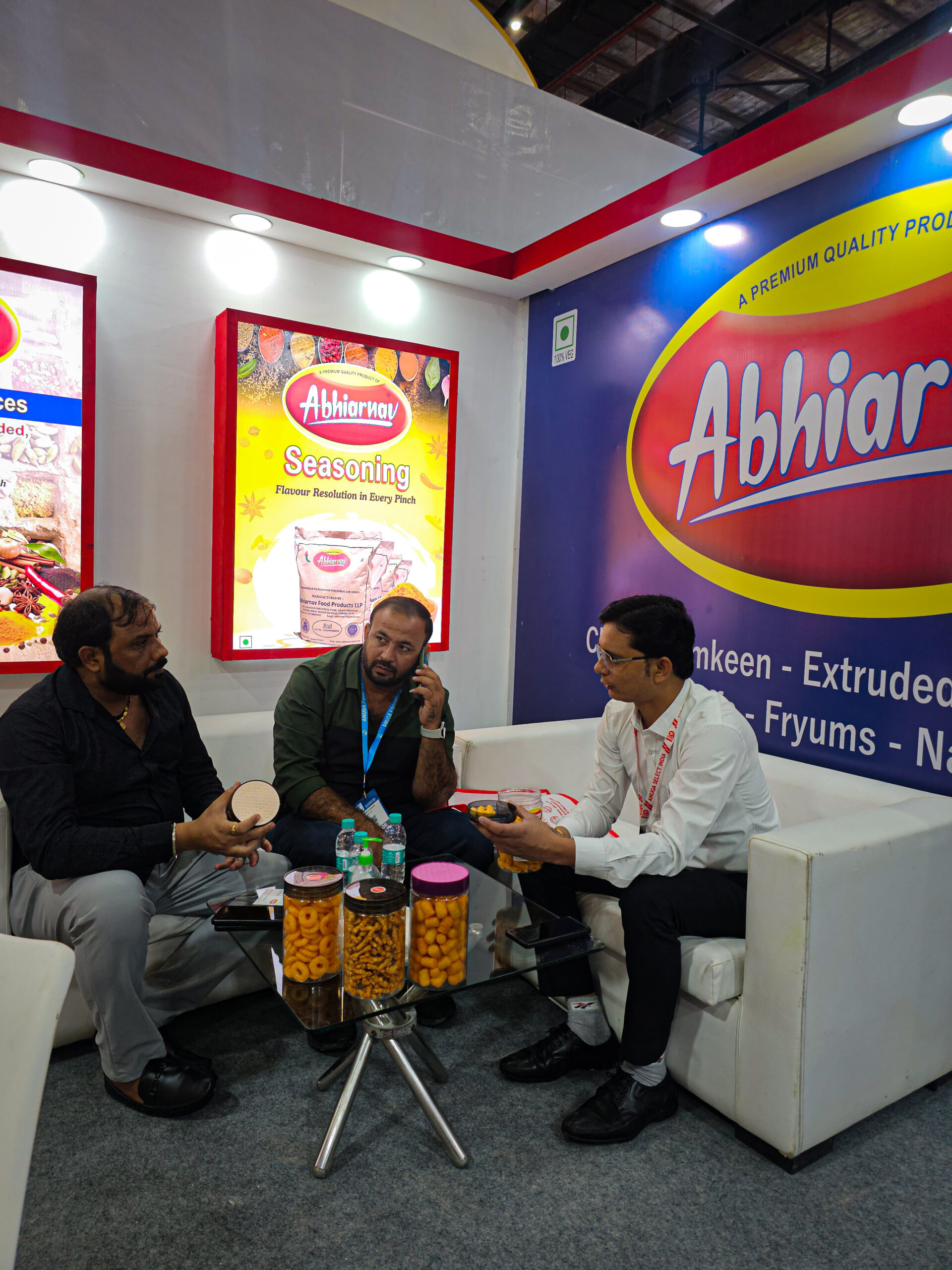 Team photo of Abhiarnav Food Products LLP representatives and visitors at Anuga Food India exhibition booth with seasoning and spices backdrop